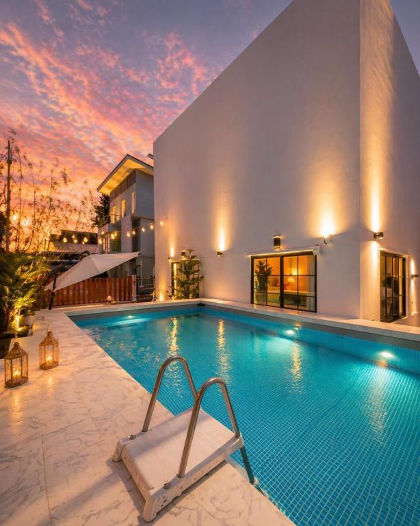 a swimming pool in front of a house at Psalms 23 Residence in Bangkok