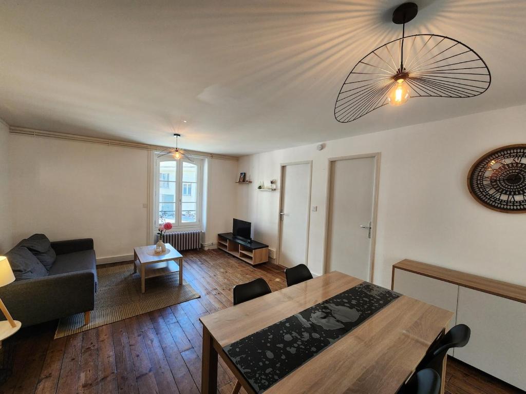 a living room with a couch and a table at Joli appartement T3 in Allassac