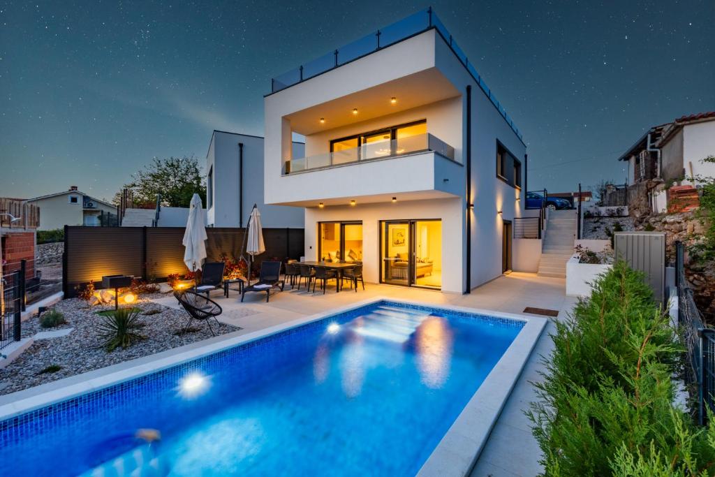 a house with a swimming pool in front of it at Villa Vela in Brzac