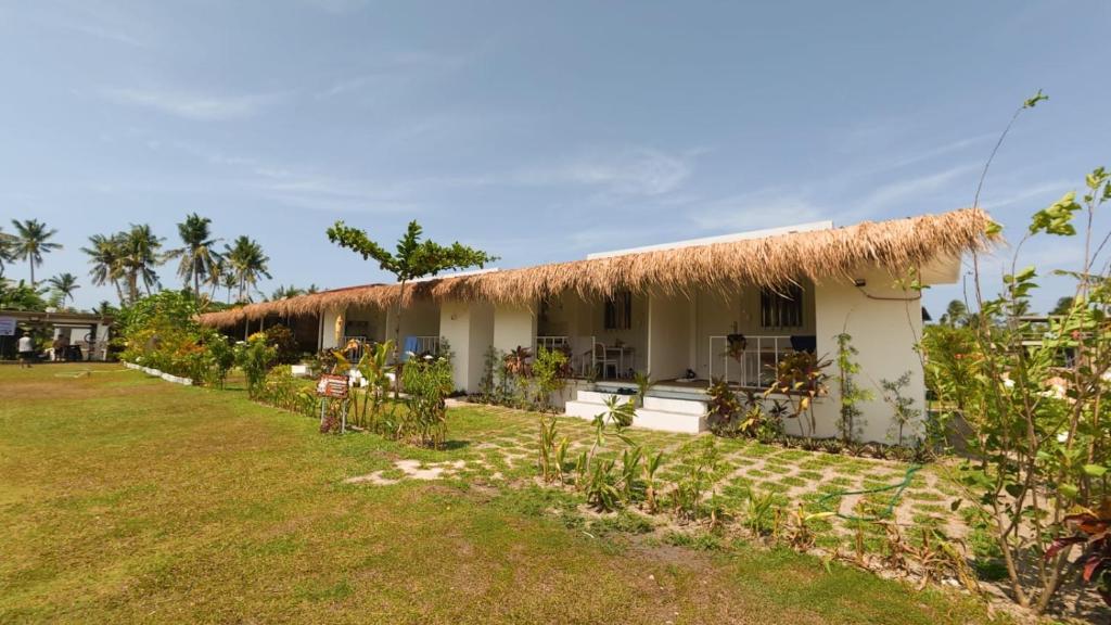 a house with a thatched roof and a yard at Crespina Private House in General Luna