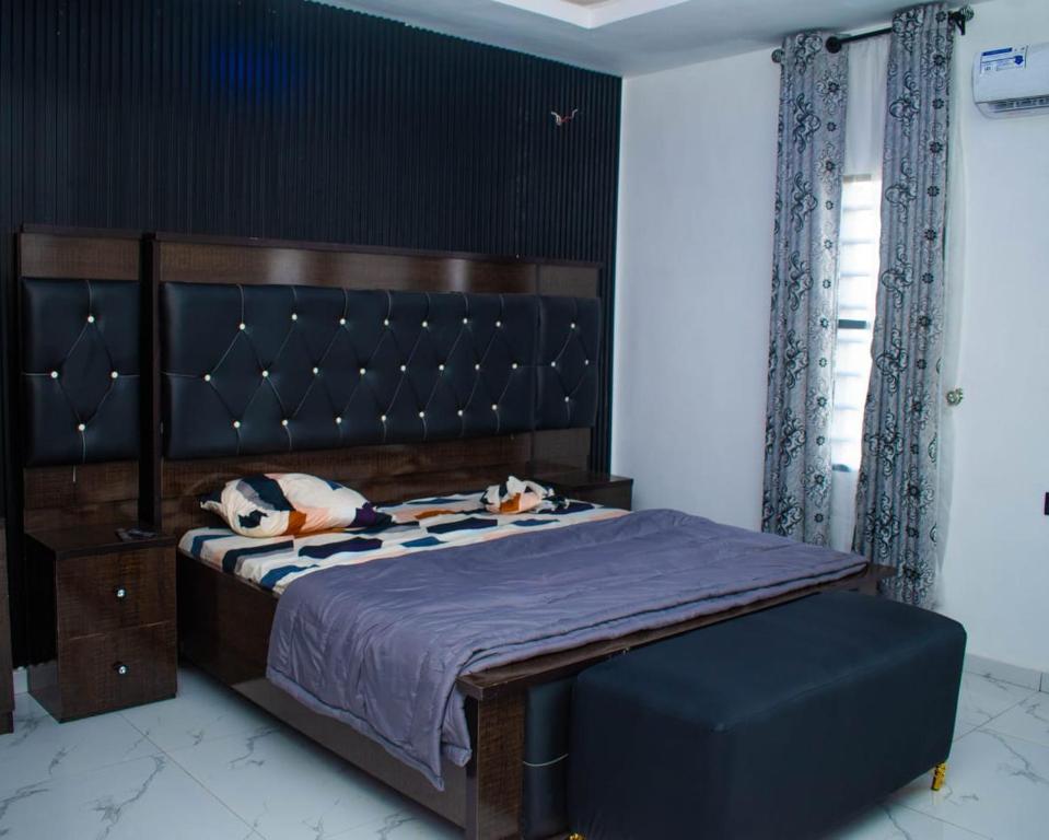 a bedroom with a bed with a purple bedspread at Isuki apartment in Benin City