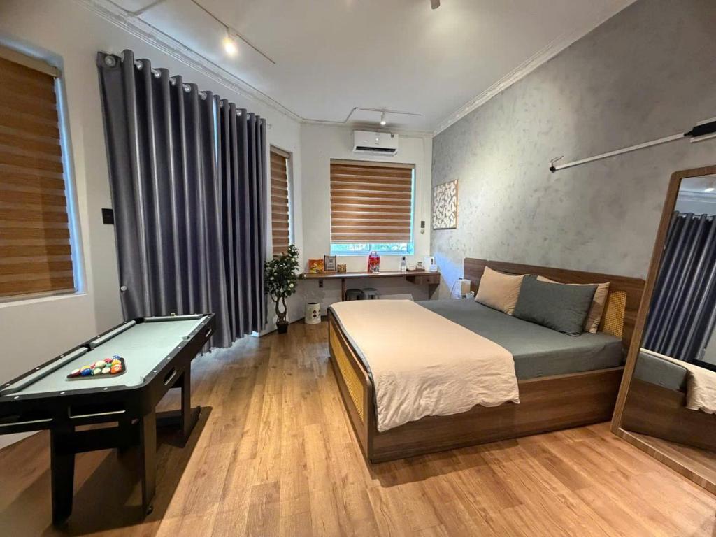 a bedroom with a bed and a table in it at Choco village 126A in Xã Thang Tam