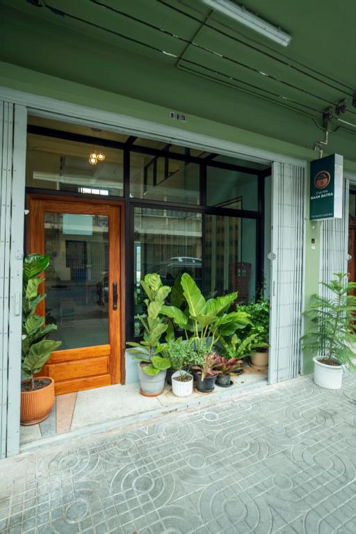 a front door of a building with potted plants at Baan Batra Heritage Suite in Bangkok