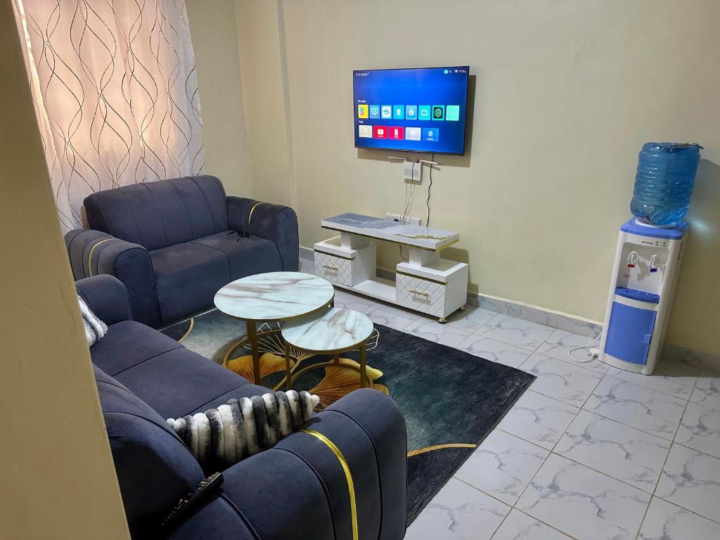a living room with two couches and a tv at The perfect Hideout in Nairobi