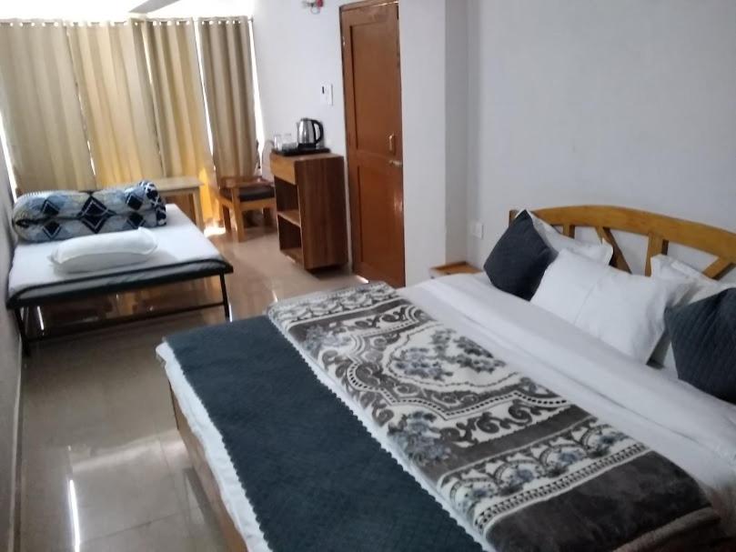 a bedroom with a large bed and a couch at Mount aura stay & Dine in Kanatal