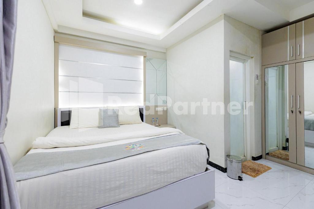 a bedroom with a bed with a large window at Tree Homestay Mitra RedDoorz in Kasri