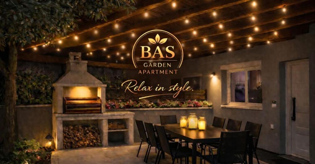 a restaurant with a table and chairs and lights at BAS Garden Apartment Paralia in Paralia Katerinis