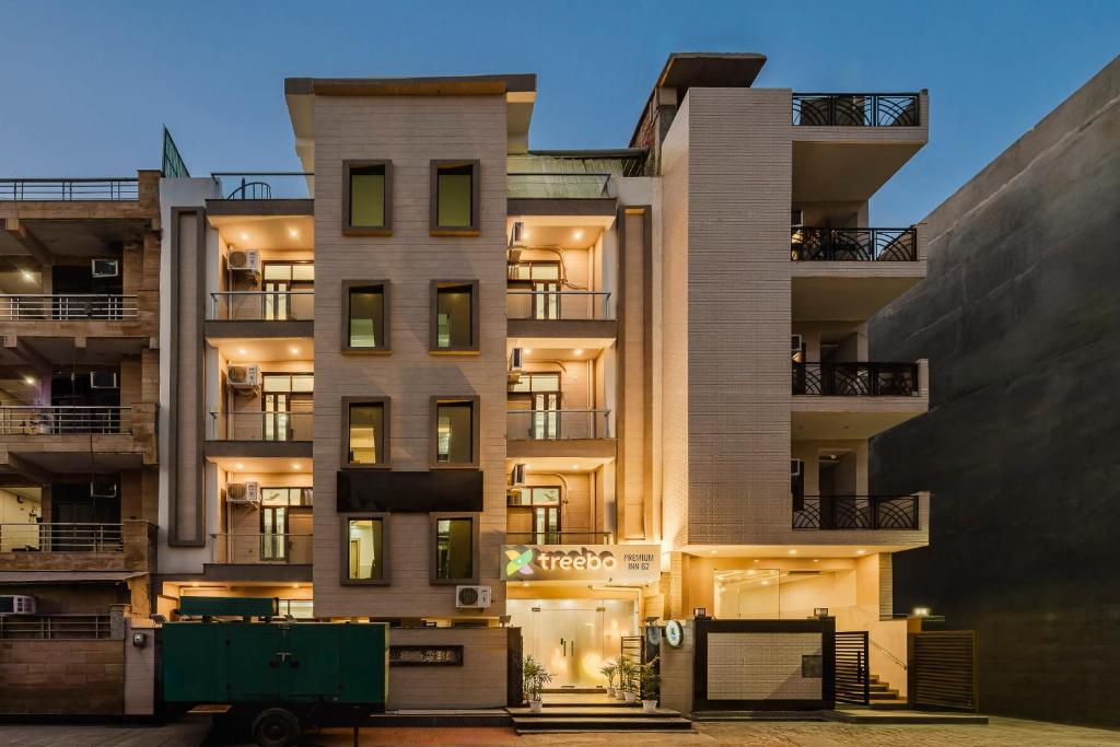 a tall apartment building with a green truck in front of it at Treebo Premium Inn 62 in Noida