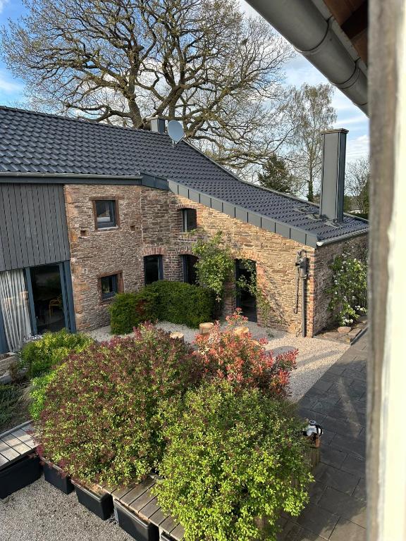 a brick house with bushes in front of it at HofZeit 1 in Mechernich