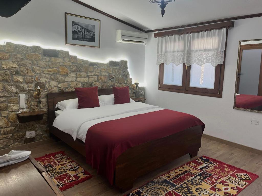 a bedroom with a bed and a stone wall at Hotel Berati in Berat