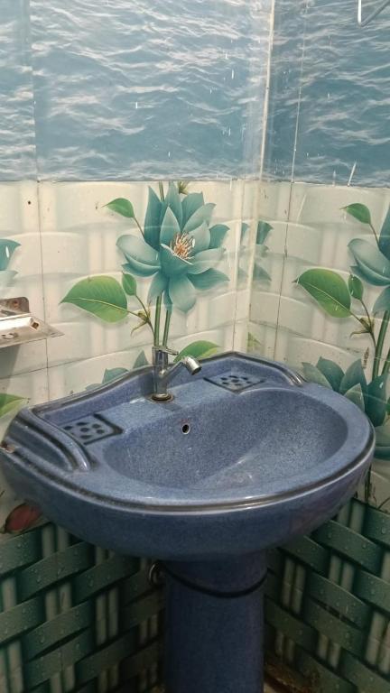 a blue sink with a flower on top of it at Hotel Raghunandan Palace in Phata