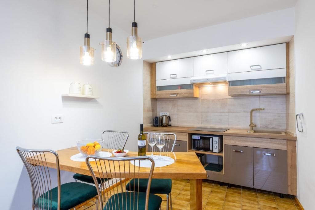 a kitchen with a wooden table and chairs at Apartman Ana Lotre in Vela Luka