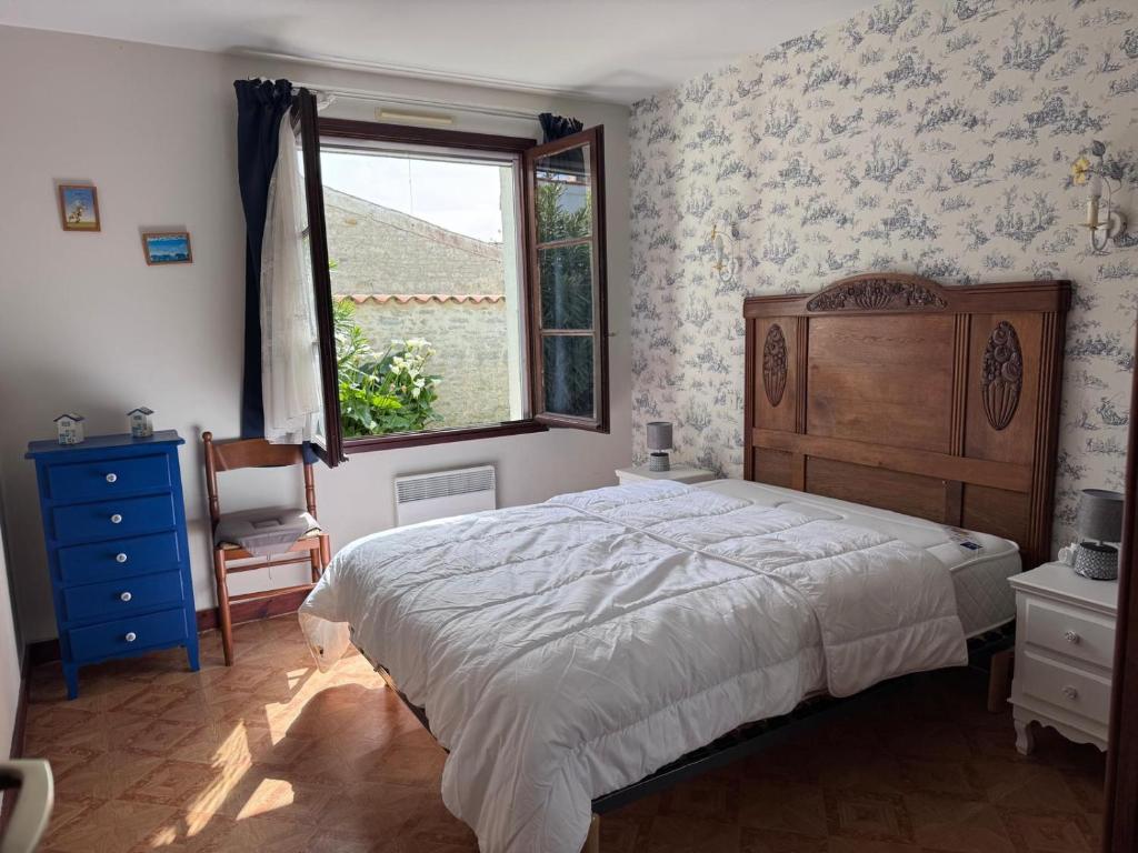 a bedroom with a large bed and a window at Maisonnette au centre de St Pierre in Saint-Pierre-dʼOléron