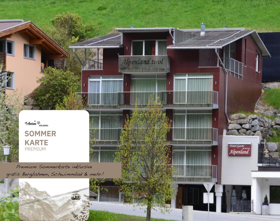 a red building with a sign in front of it at Hotel Alpenland in Sankt Anton am Arlberg