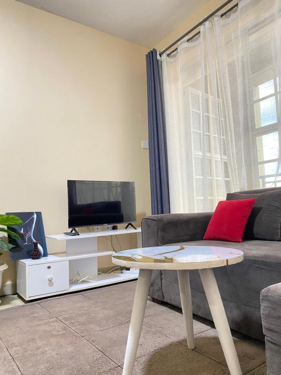 a living room with a couch and a table at Kin Bnb in Ruaka