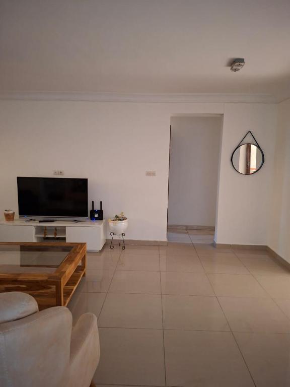 a living room with a couch and a tv at Monica Place in Abidjan
