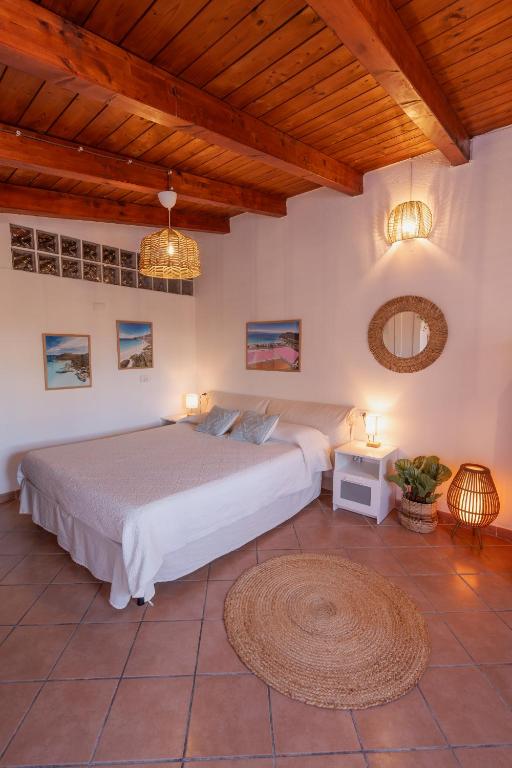 a bedroom with a large bed and a wooden ceiling at Le Gioie di Laura in Su Forti