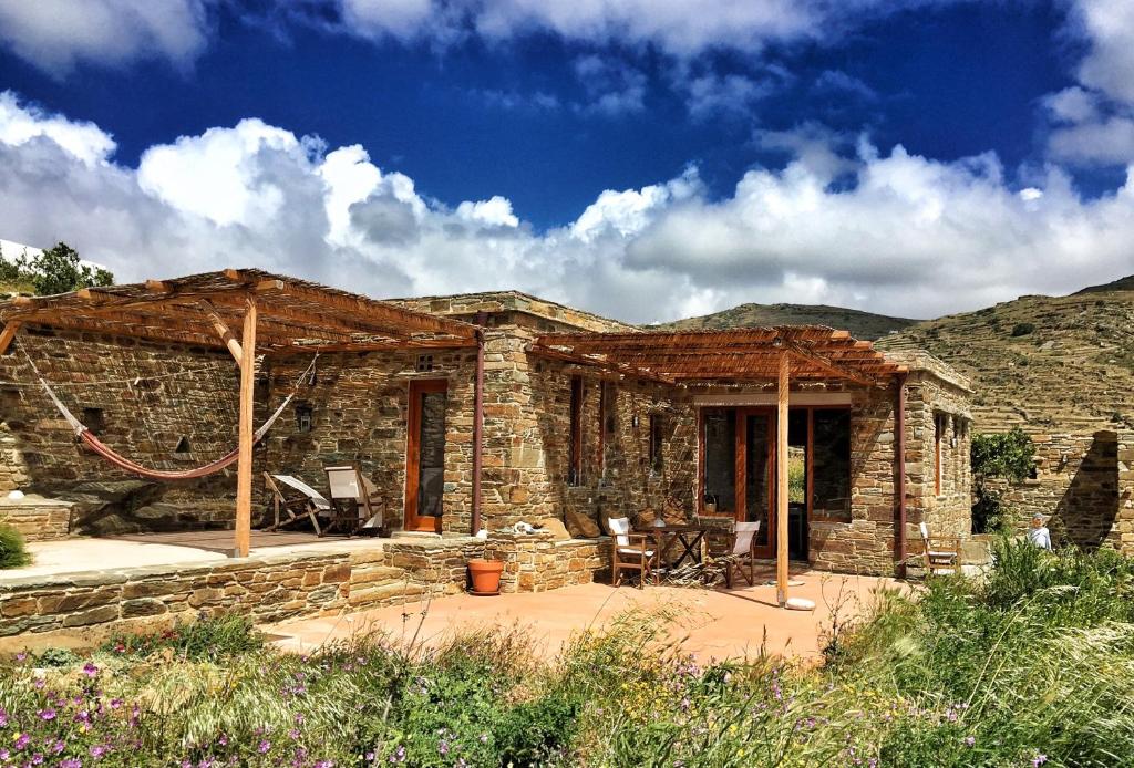 a stone house with a patio in front of it at Tinos Ecolodge in Tinos
