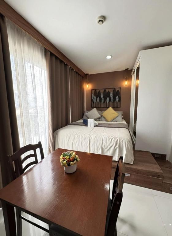 a bedroom with a bed and a table with a bowl of flowers on it at Residencias Lim - Cityscape Residences in Bacolod