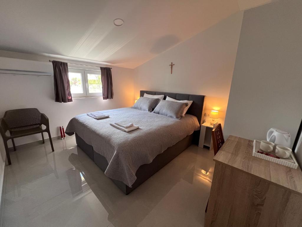 a bedroom with a bed with a cross on it at ROOMS Međugorje in Međugorje