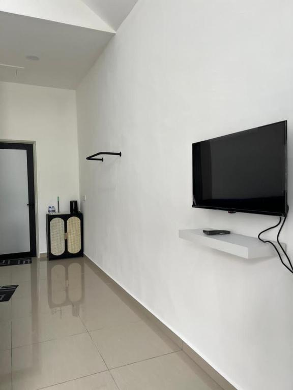 a white room with a flat screen tv on a wall at Gopeng Tiny House CUCHU in Gopeng