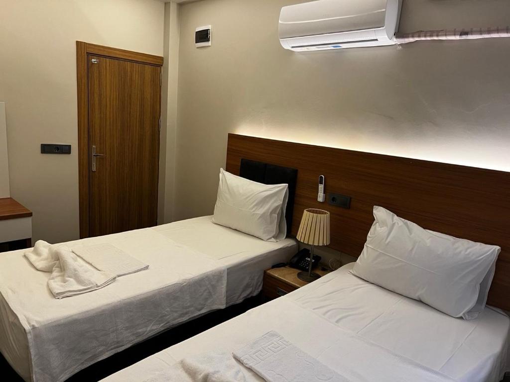 a hotel room with two beds and a fan at Hotel Bergama in Istanbul