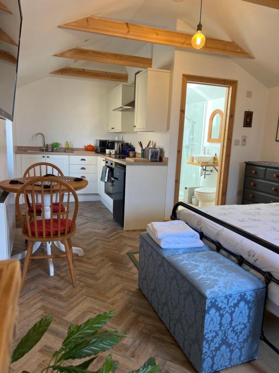 a kitchen with a couch and a table in a room at Mini Treacle Cottage in Dundry