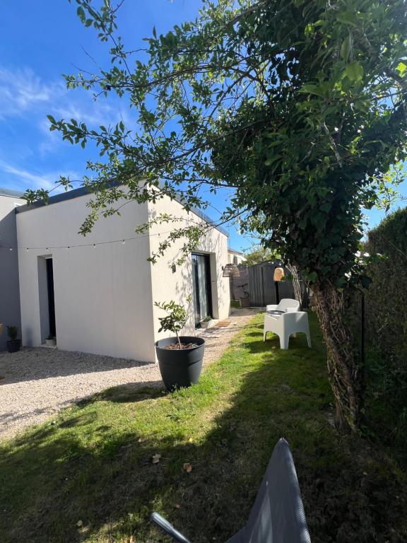 a yard with a white building and a tree at Quiniere - 25 m2 indépendant avec piscine - Wifi in Blois