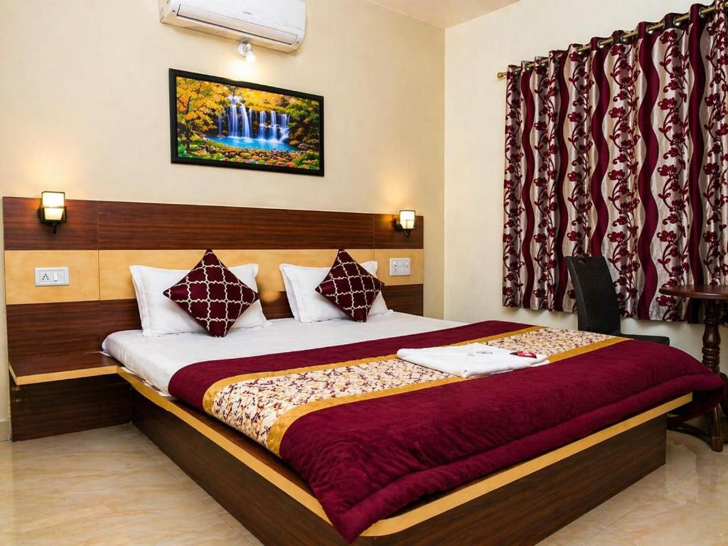 a bedroom with a large bed with red curtains at Hotel Matheran Gaurav Cottage in Matheran