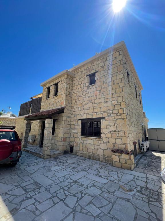 a stone building with a car parked in front of it at Villa Balmoral in Peyia