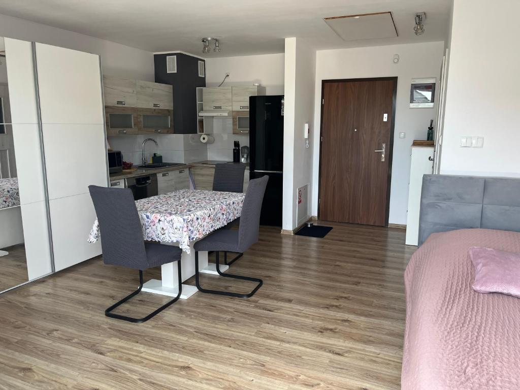a room with a table and chairs and a kitchen at Studio Green in Świebodzice