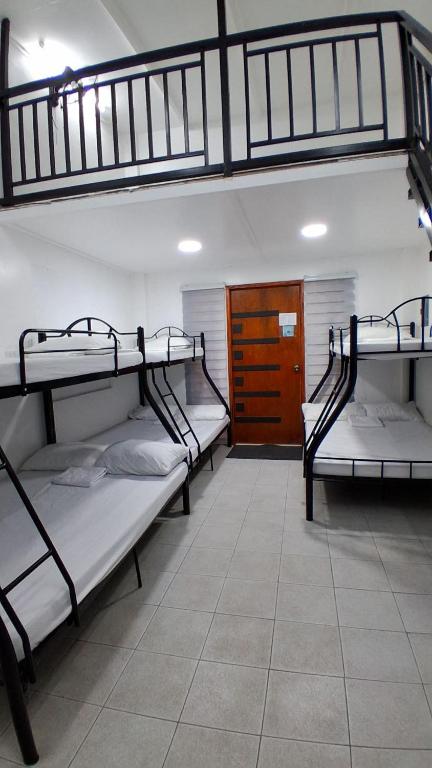 three bunk beds in a room with a door at Starksway Resort in Calubcub Primero