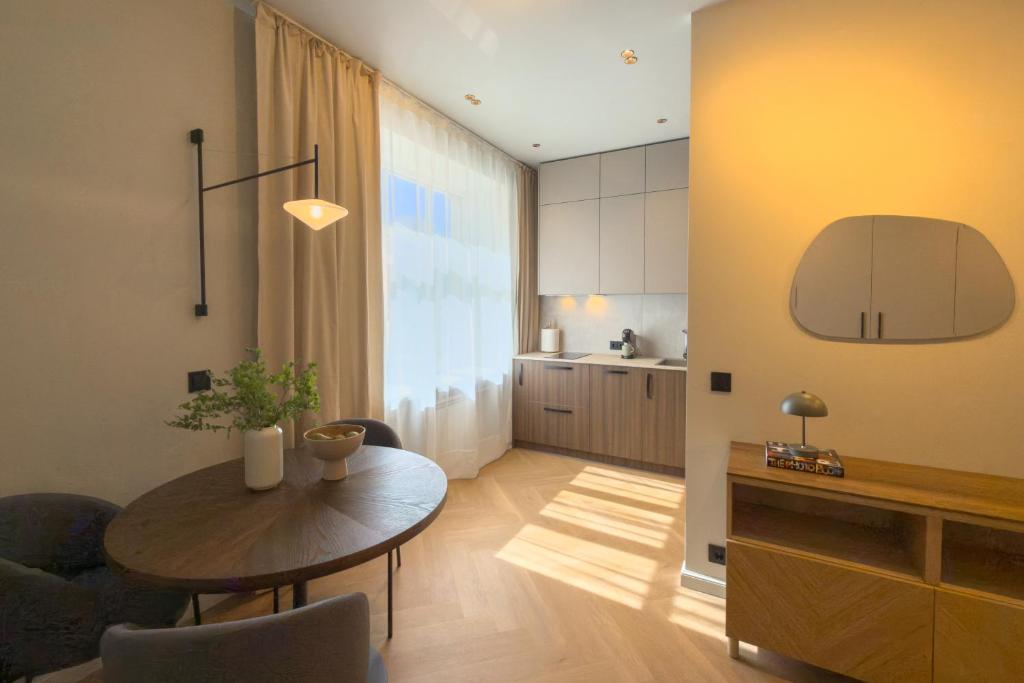 a living room with a table and a kitchen at NIDO Park view in Daugavpils