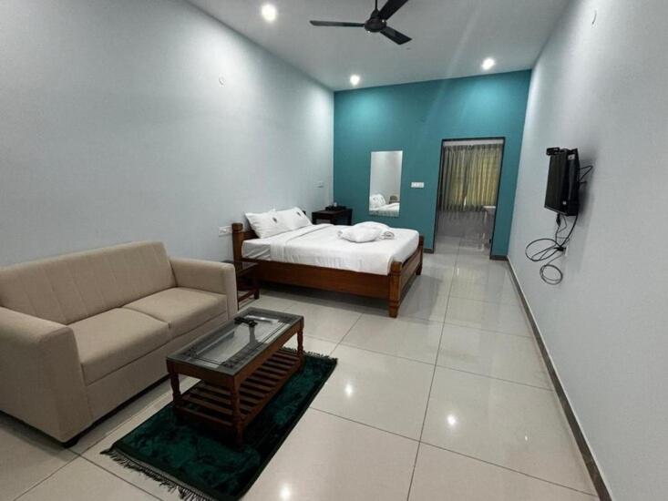 a living room with a bed and a couch at Richmount Natural Resort Pvt Ltd in Yercaud