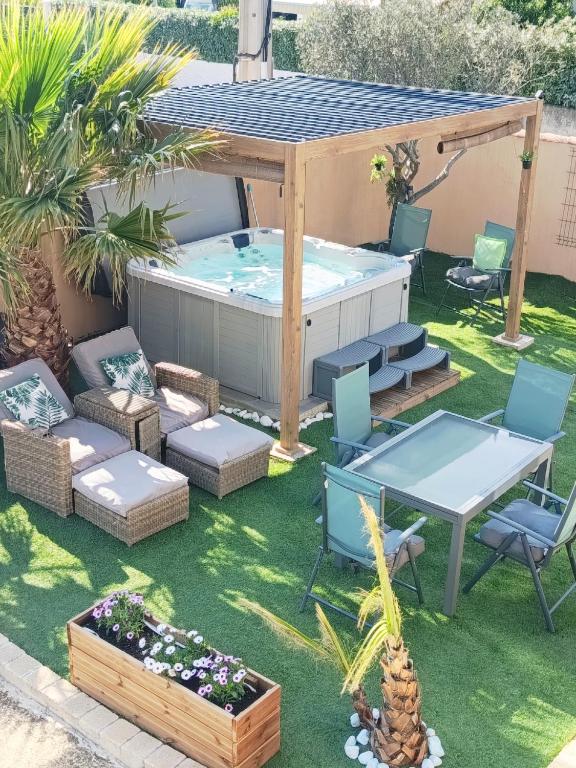 a backyard with a hot tub and a table and chairs at LA LIBELLULE de PROVENCE in Morières-lès-Avignon