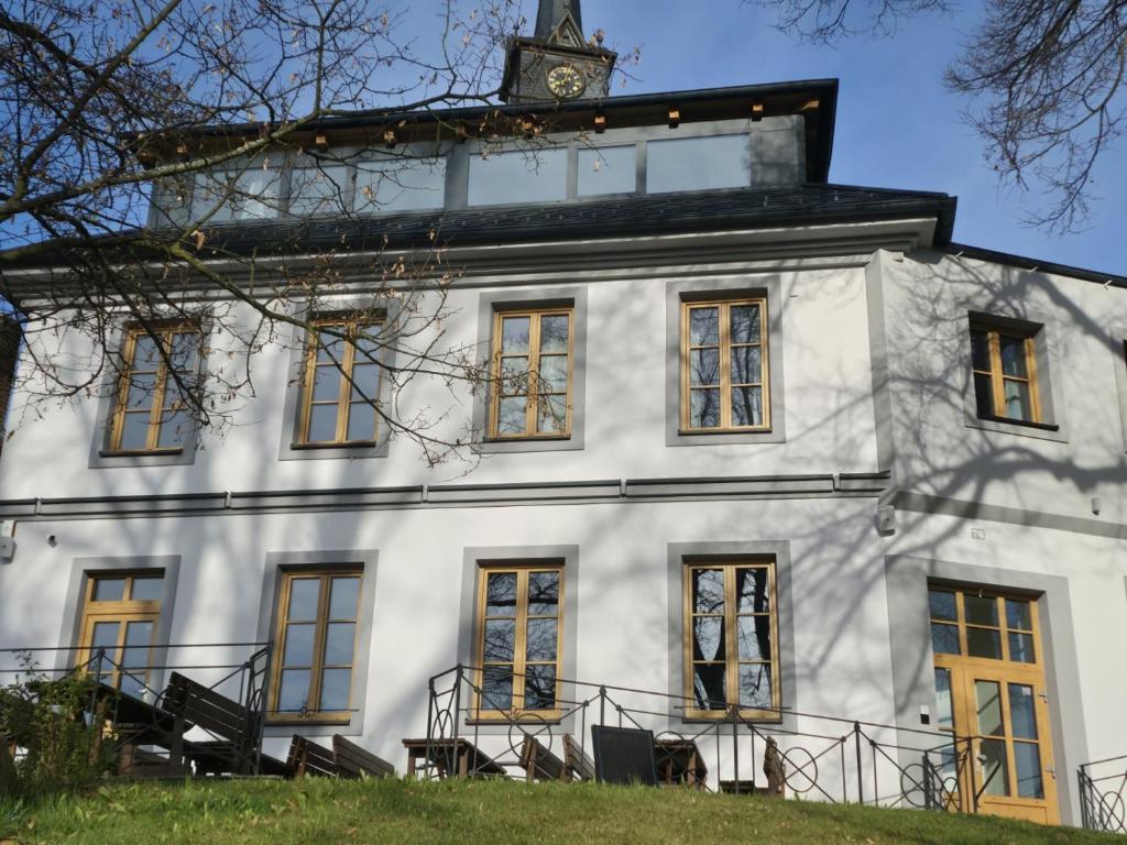 a white building with a clock tower on top of it at hostINNec in Dolní Dvořiště