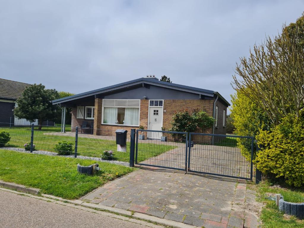 a house with a fence in front of it at Bungalow Nathalie in Julianadorp