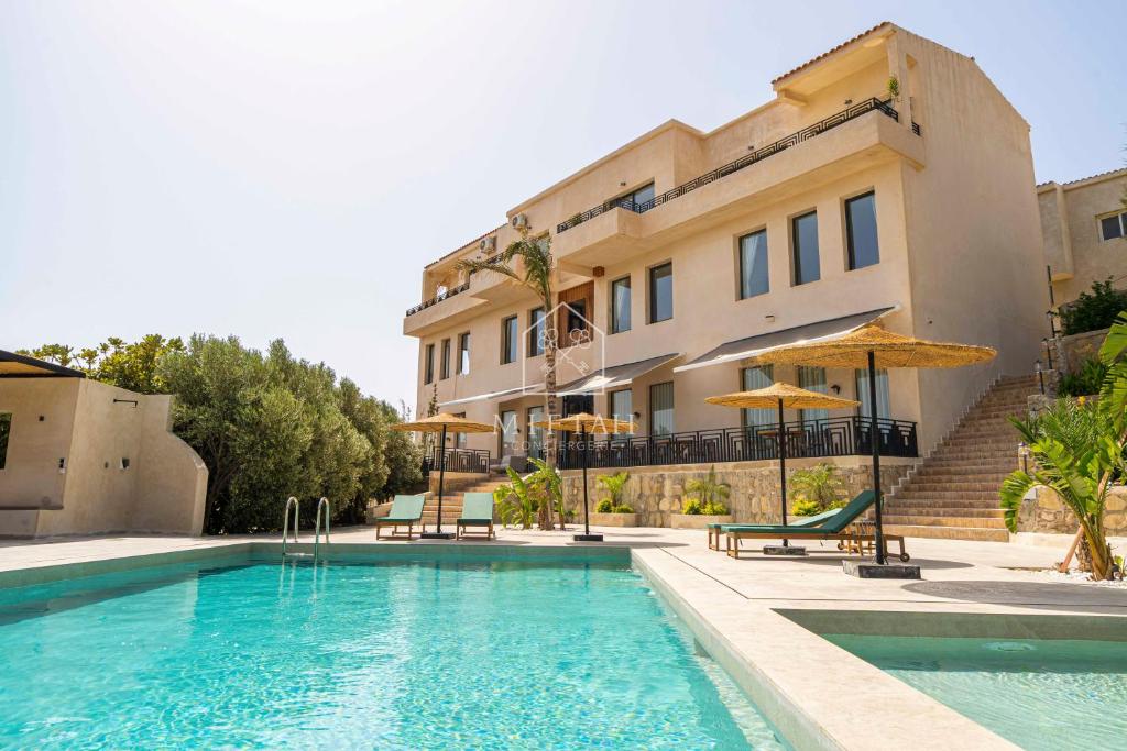 a swimming pool in front of a building at Chambre avec vue panoramique in Noûnouech