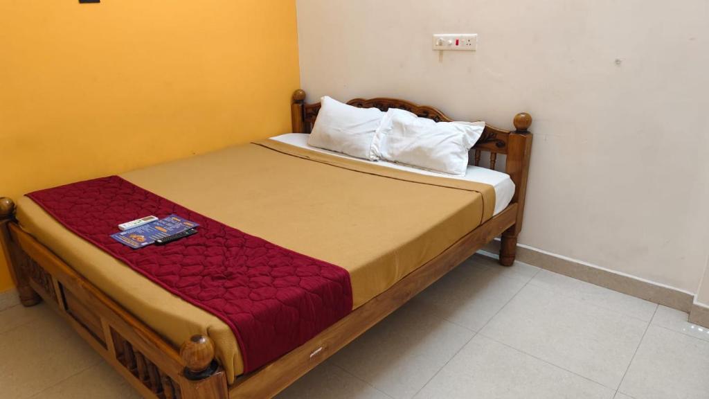 a bed in a room with a wooden frame at Priyan Beach View Residency in Kuilapayam