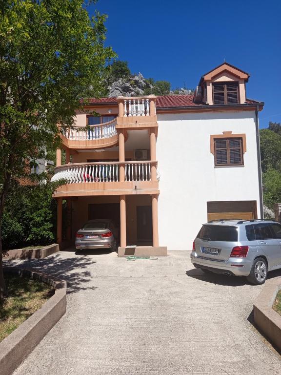 a house with two cars parked in front of it at Apartman Selena in Trebinje