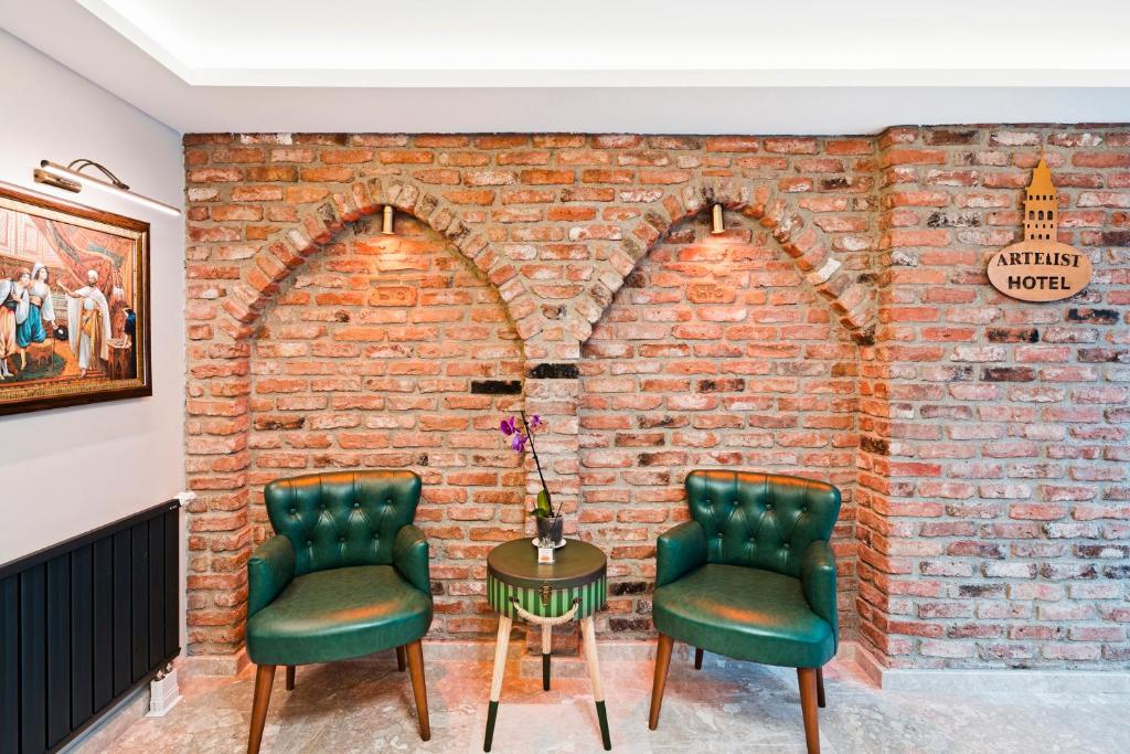 two chairs and a table in front of a brick wall at Taksim Artelist Hotel in Istanbul