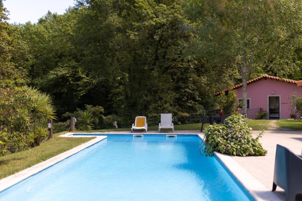 a swimming pool with two chairs and a house at Geres parque in Geres