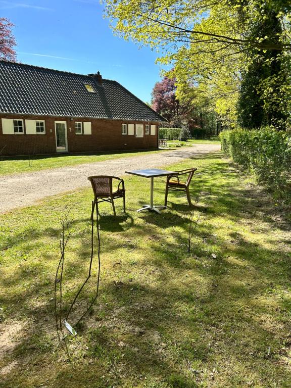 a picnic table and a bench in a yard at Tussen Heide en Bos, unwind in nature in Opglabbeek