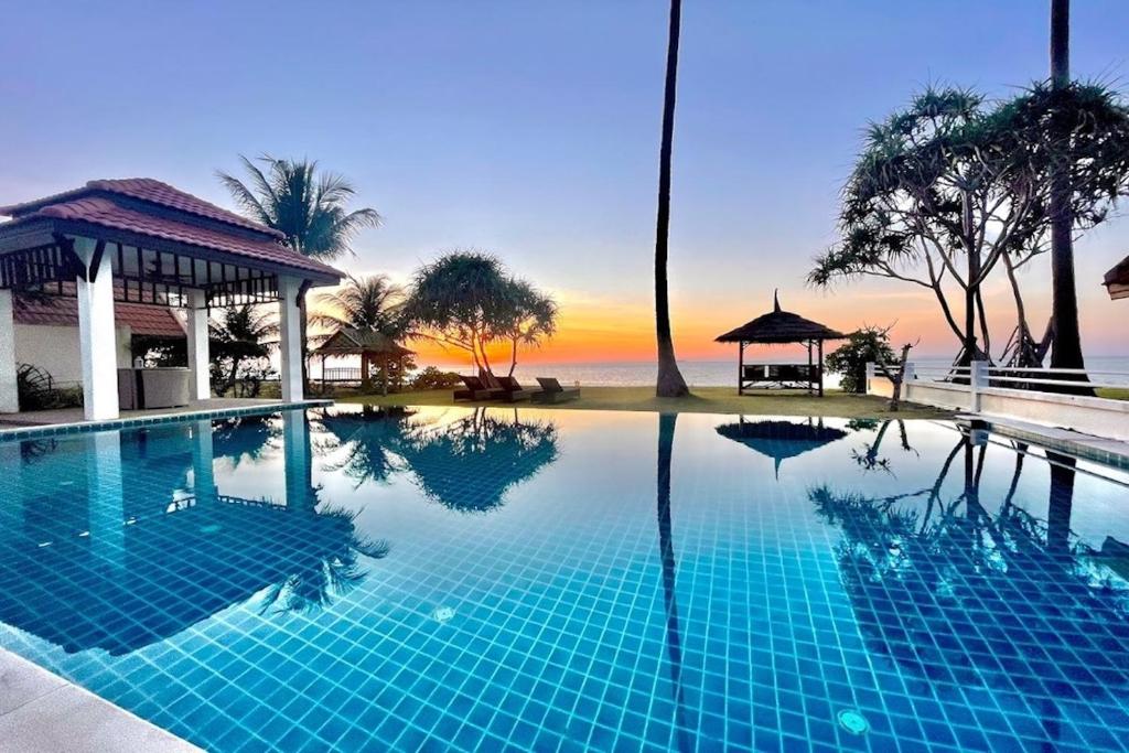a swimming pool with a view of the ocean at Beachfront! 4 Bedrooms - Malee Beach Villa E6 in Phra Ae beach