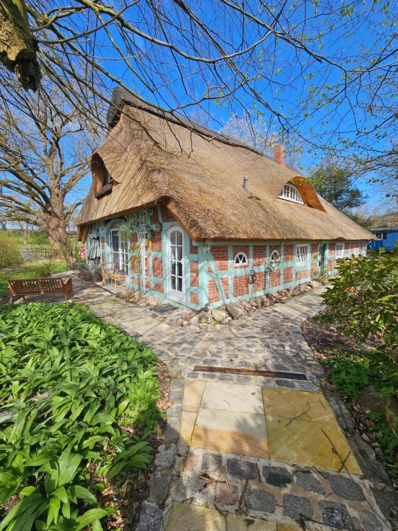 a large house with a thatched roof at Appartment Casa Verde in Lübberstedt