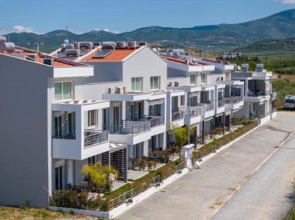 a row of white apartment buildings on a street at Nefeli's 13,6 Apartment in Orfánion