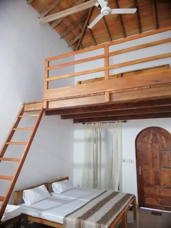 a bedroom with a bunk bed and a ladder at Laxmi Villa in Kalkudah