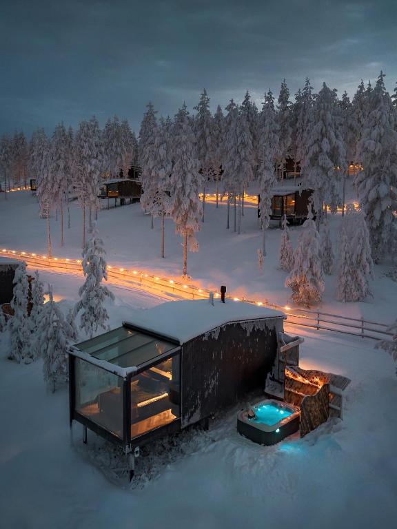 a house in the snow at night with lights at Arctic Lumo Resort in Kuusamo