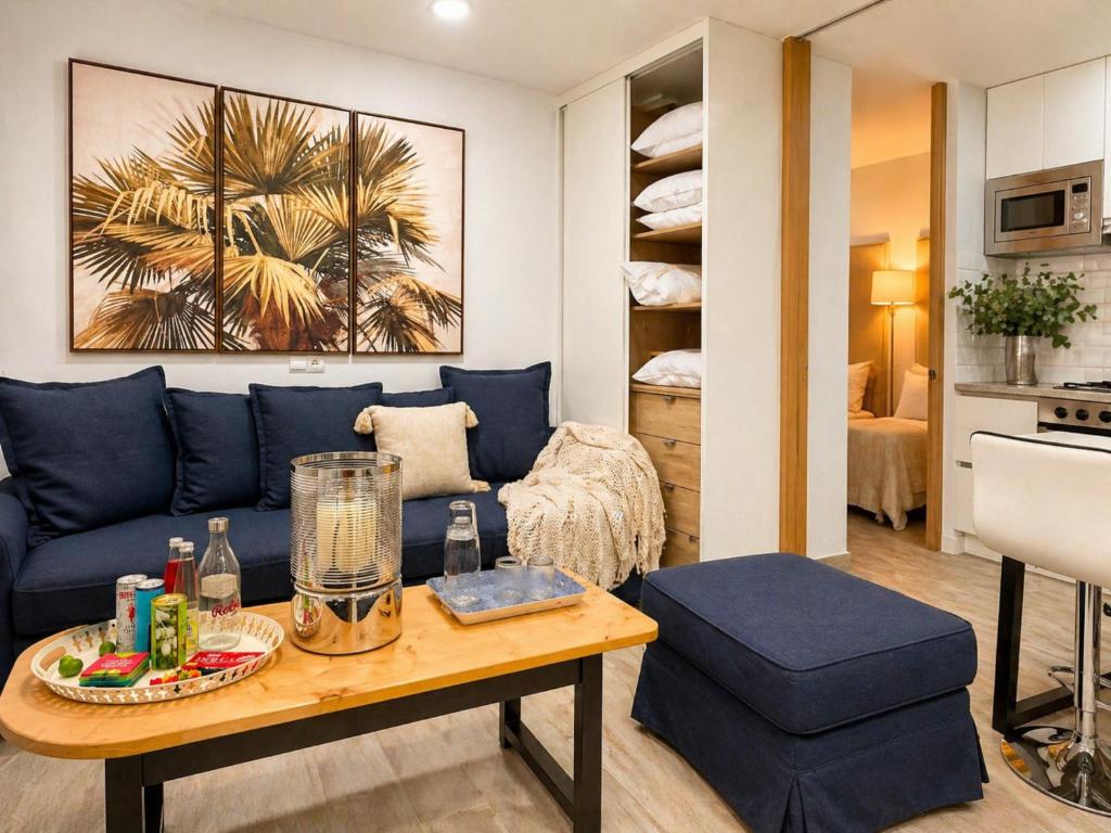 a living room with a blue couch and a table at Estudio Céntrico con Entrada Privada - Self Check-in HAZA ROYAL in Granada
