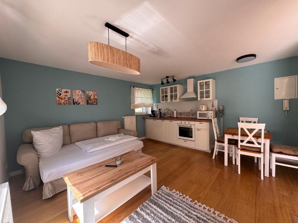 a living room with a couch and a kitchen at Landhaus Buckow in Buckow